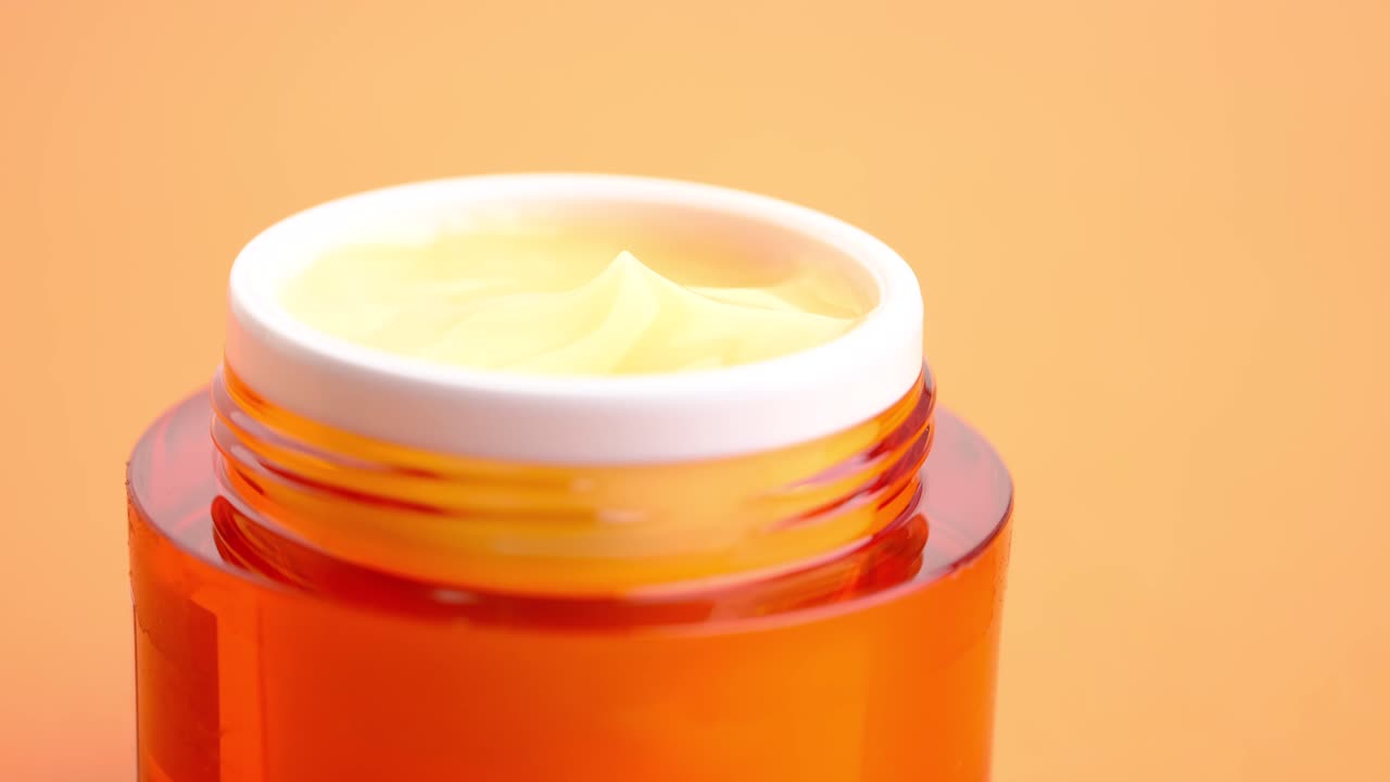 un frasco de crema facial de naranja