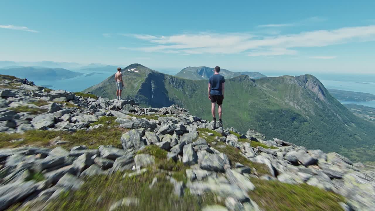adultos jóvenes exitosos llegaron a la cima de la montaña, vista de drones fpv del majestuoso paisaje