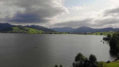 Serene-aerial-panorama-of-alpine-Sihlsee-lake,-Switzerland-on-rainy-day