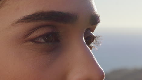 close up of beautiful eyes woman enjoying view relaxing on summer vacation contemplating future looking at sunny outdoors