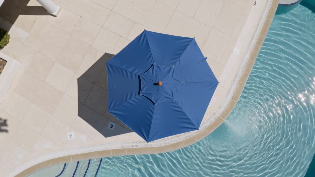 Starting pool return creating ripples as blue octagonal umbrella casting shadow view showing steps