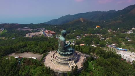 aerial orbit around tian tan buddha famous statue on top of hill at lantau island, hong kong