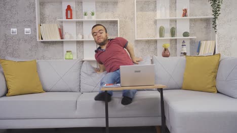 hombre enano feliz y positivo trabajando remotamente en línea desde casa en una computadora portátil.