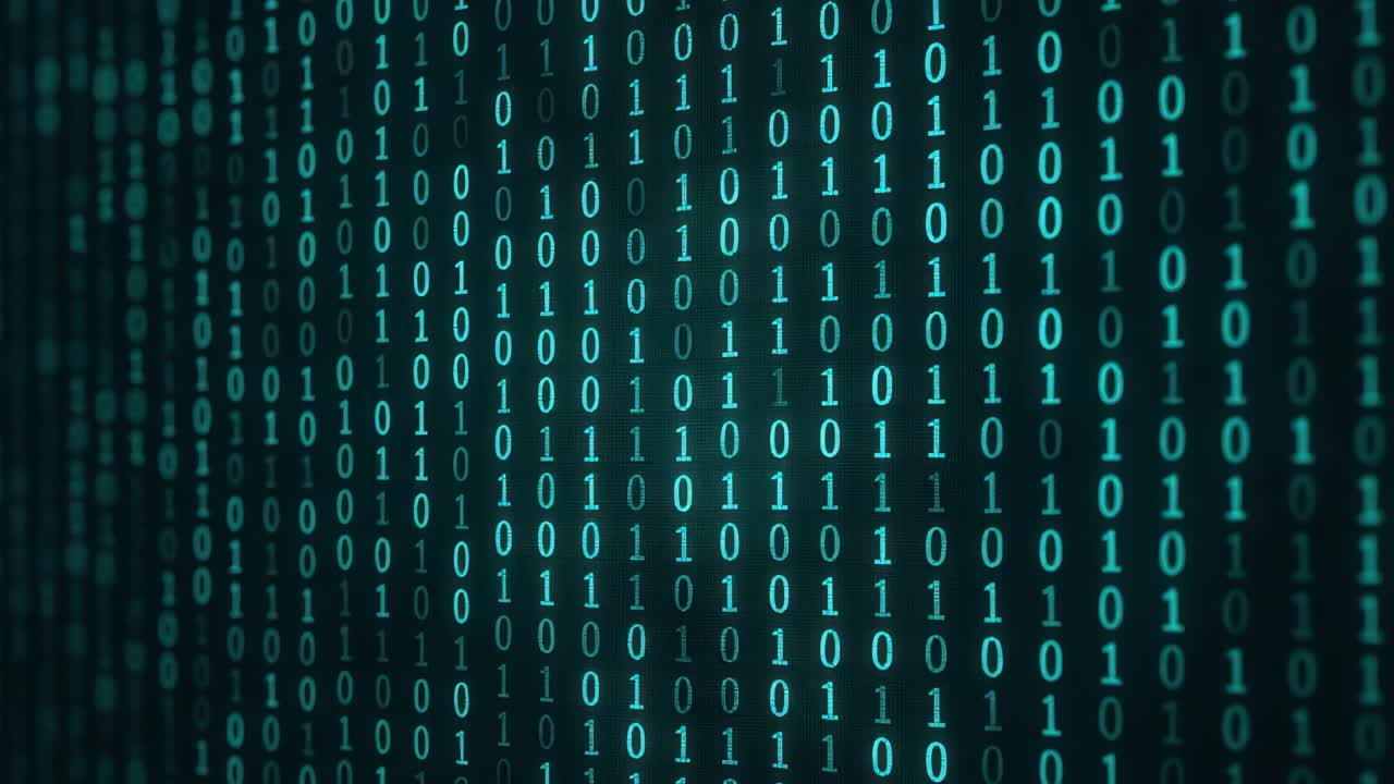 A digital matrix of binary code in teal on a dark background. The video captures a close-up, angled