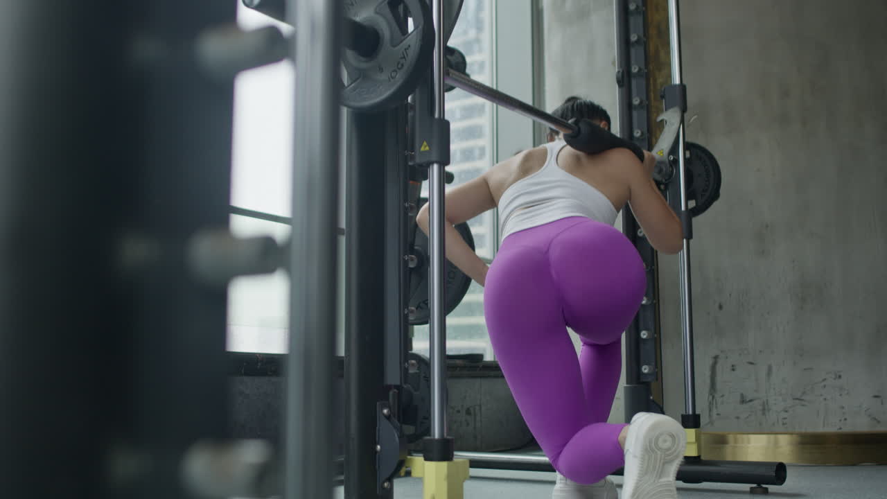 mulher jovem a fazer back lunge squats no ginásio, manter-se em forma, exercícios de corpo inteiro