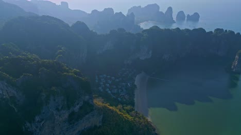 towering limestone cliffs on ao nang during foggy morning in krabi province, southern thailand