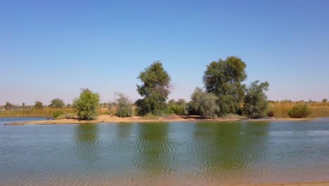 Driving-by-a-man-made-lake-in-Al-Qudra-Dubai-United-Arab-Emirates-UAE