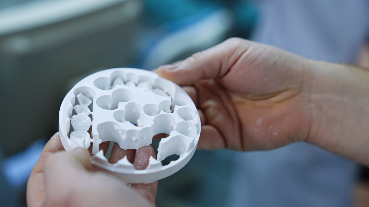 Male hands hold dental blanks high strength for temporary crown. Dentistry and ceramic implantation. Close up.