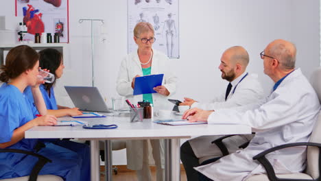 mature doctor presenting new medical procedures standing at desk