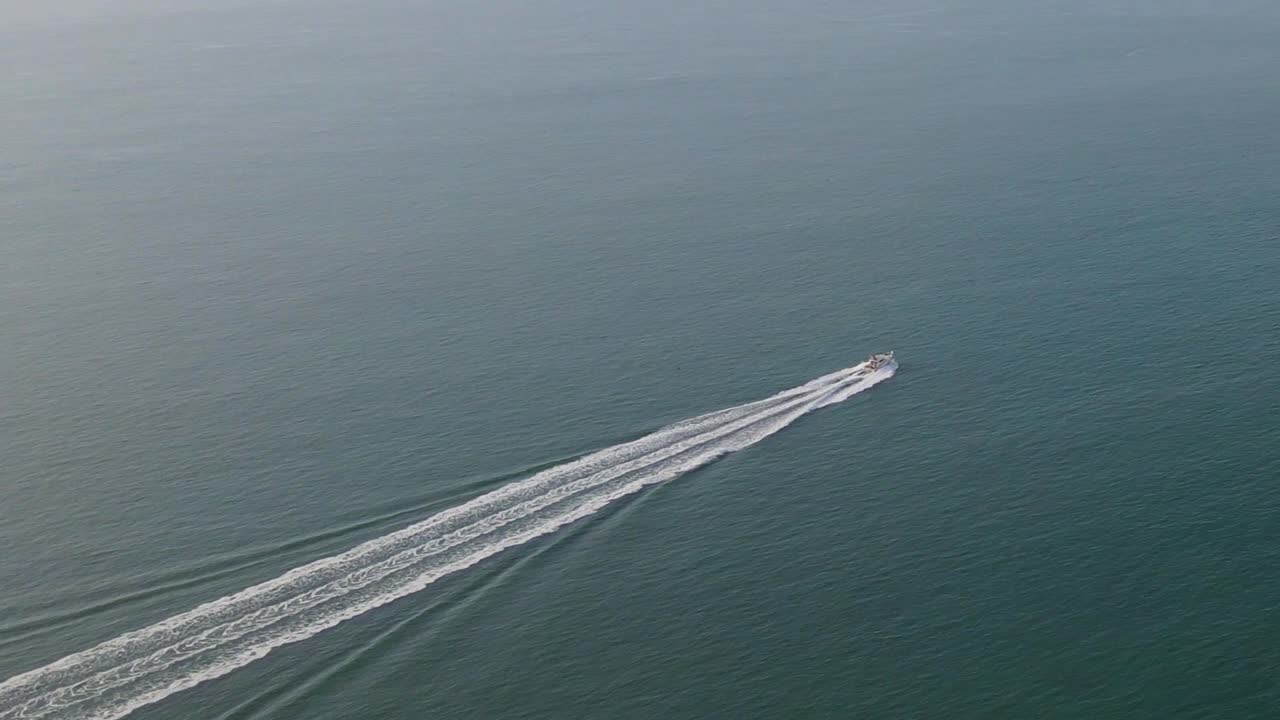 lancha rápida aislada deja estela blanca sobre aguas azules y tranquilas