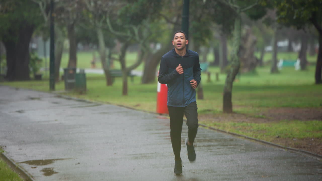 비가 오는 공원에서 달리는 남자