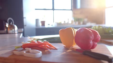 Verduras-Orgánicas-Y-Cuchillo-Sobre-Encimera-En-Cocina-Soleada,-Cámara-Lenta