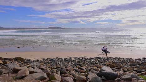 Surfer,-Die-Mit-Surfbrettern-Am-Strand-Laufen---Blauer-Himmel-Mit-Weißen-Wolken-über-Dem-Ozean---Crescent-Head,-Nsw,-Australien