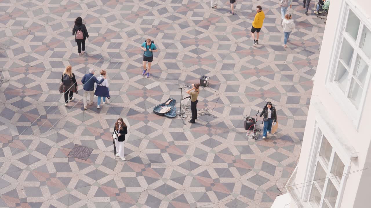 Static high angle view of street artist singer perform in public, Copenhagen