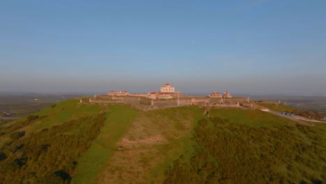 ascending aerial shot of historic conde de lippe fort during sunset time in elvas,portugal - beautiful architecture castle on mountaintop in rural area