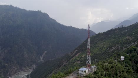 mobile communication tower at the top of a mountain with shelters and surrounded mountain landscape