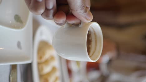 hand holding a coffee cup at a restaurant