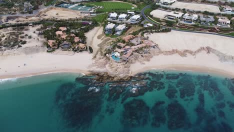 vista aérea sobre una costa de ensueño con vista a la maravillosa playa, el mar turquesa con rocas en el agua y varias casas de vacaciones y complejos hoteleros en la playa de chileno durante un viaje a través de méxico