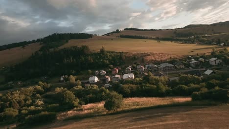 aerial footage from an action camera flying low approaching a small herd of sheep grazing on a meadow with yellow dry grass on hill in cierny balog, central slovakia
