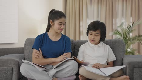 indian sister helping her brother in studies