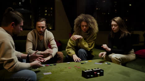 grupo de amigos jugando al póquer sentados en el sofá de la sala de estar 2