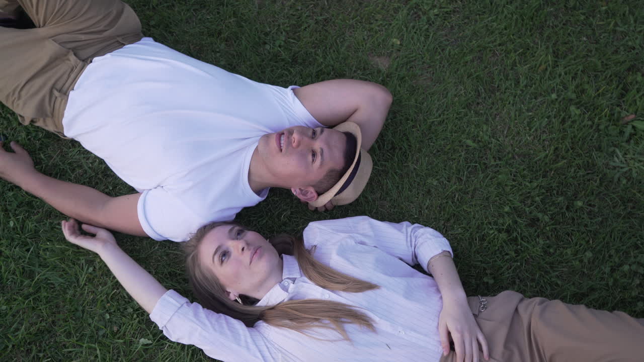 couple lying on the grass. Top view