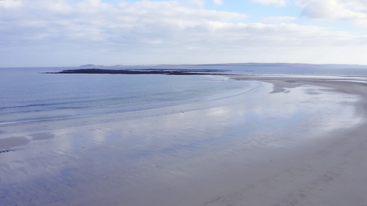tiro de drone de la playa de gress con marea baja con un punto en el fondo en las hébridas exteriores de escocia
