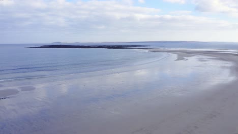 tiro de drone de la playa de gress con marea baja con un punto en el fondo en las hébridas exteriores de escocia