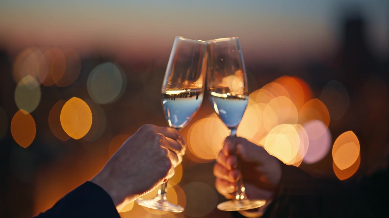 Close up champagne glasses clinking sunset city lights. Hands toasting drinks.