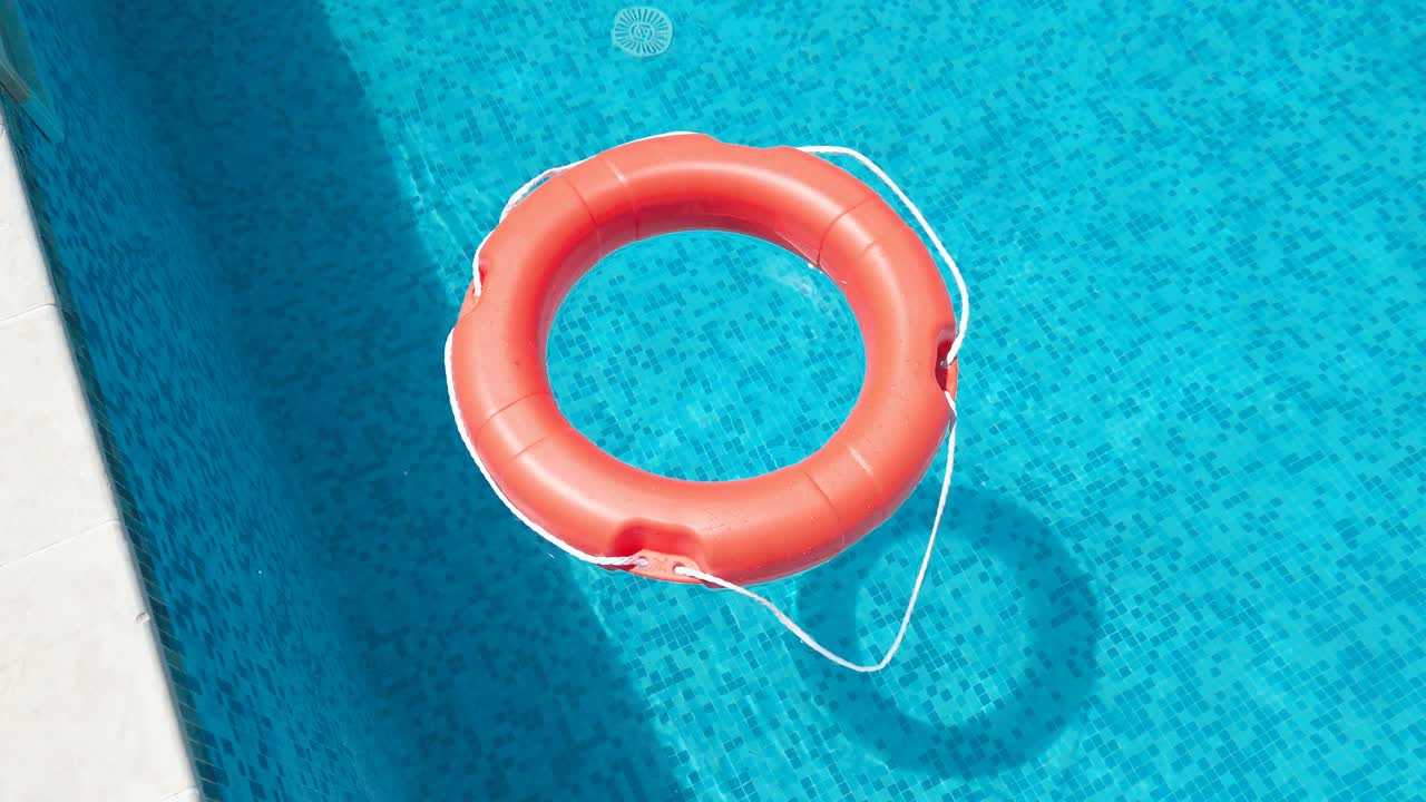 Safety equipment, Life buoy or rescue buoy floating on swimming pool to rescue people from drowning man, slow motion