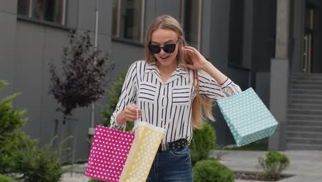 Teenager-girl-in-trendy-clothes-with-multicolor-shopping-bags.-Black-Friday-sale-discounts-concept