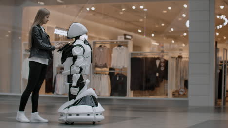 a female programmer tests the robot for the ability to interact with users. the use of a robot assistant in the office. the robot gives help to the girl