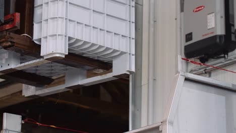 Full-harvest-bin-with-white-wine-grapes-being-tipped-into-crusher-de-stemmer-with-forklift