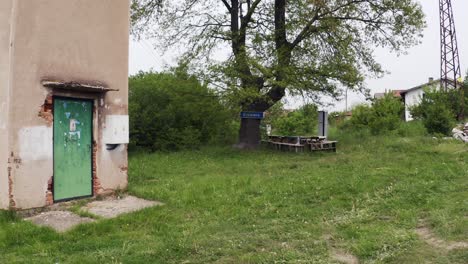 Toma-De-Drone-Acercándose-A-Un-Edificio-Antiguo,-Un-árbol-Emblemático,-Bancos,-Torre,-En-El-Barrio-De-Tsarichina-Hole-En-Bulgaria