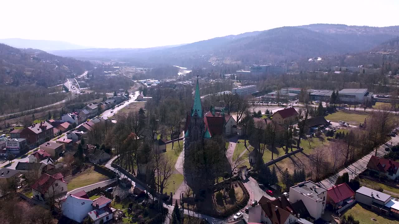 Aerial cinematic shot of huge old church located in the small town