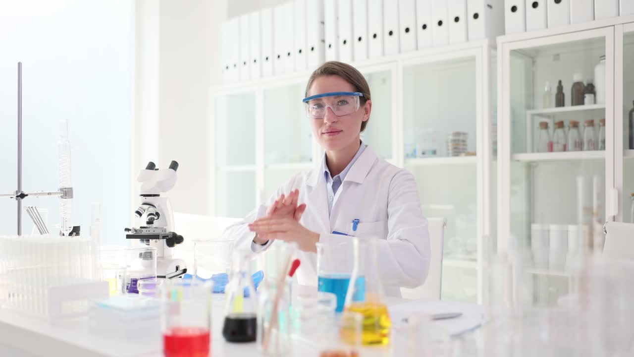 Female Scientist in Lab Coat and Safety Glasses Working in a Laboratory