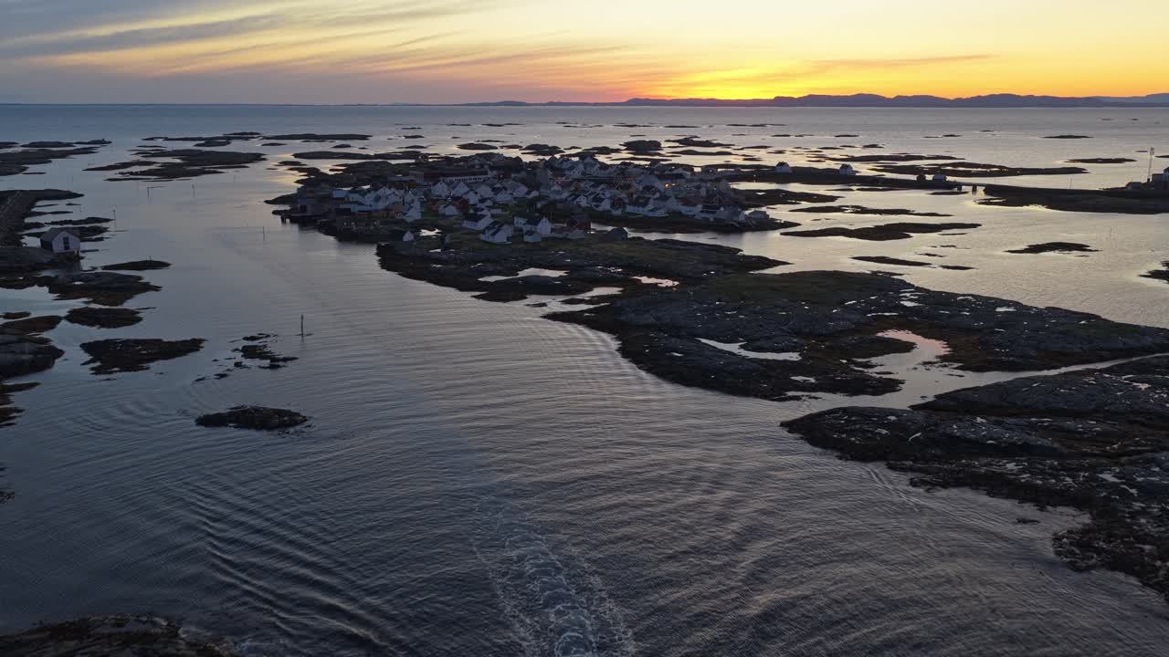 Färgstarkt gryningsljus speglas i båtar nära Veiholmens hamn, Norge, drönarvy