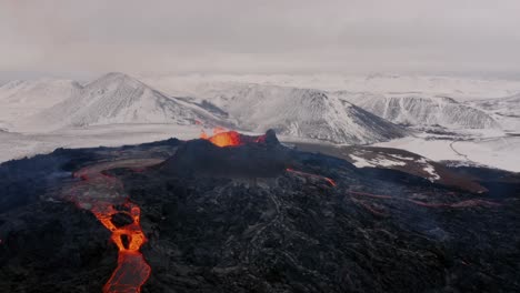 Aerial-cinematic-shots-captured-by-a-4K-drone-showcase-a-snowy-mountain-with-an-erupting-volcano-in-the-foreground