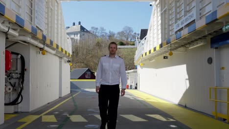 Ferryboat-captain-walking-towards-camera-in-slow-motion,-stops-and-looking-at-camera