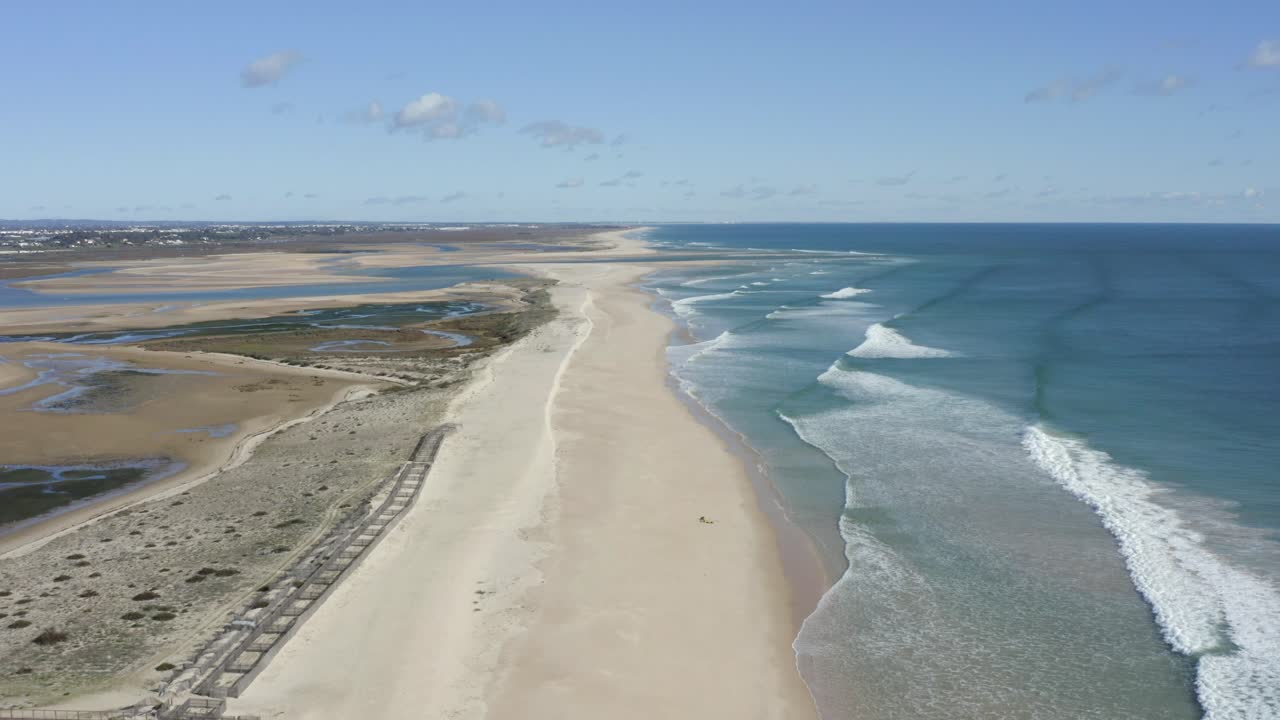 volando sobre una playa dorada en la isla om fuseta mientras las olas se estrellan desde el océano atlántico