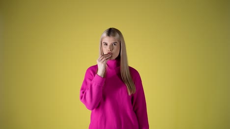 Young-caucasian-woman-biting-a-delicious-chocolate-cookie-on-yellow-background