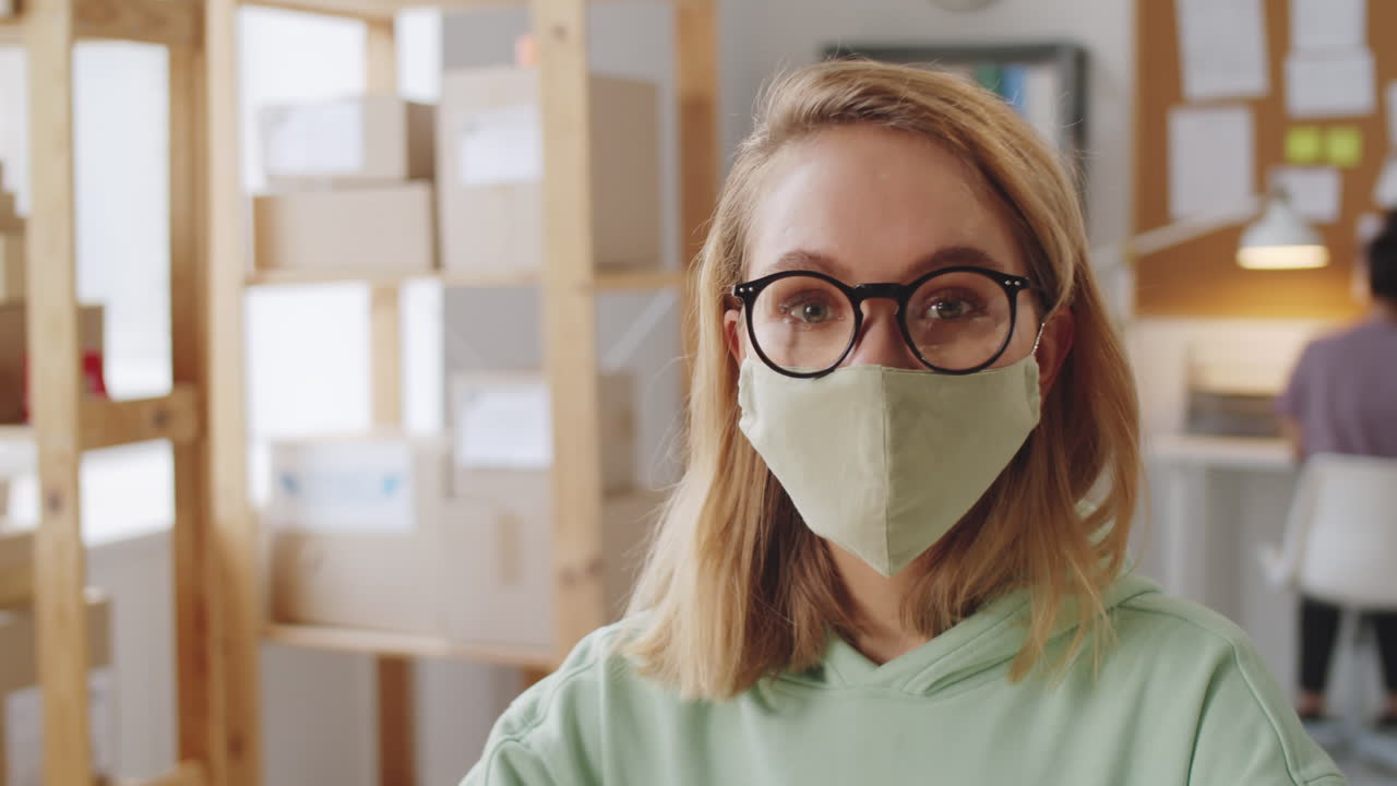 mujer con una máscara en un lugar de trabajo moderno