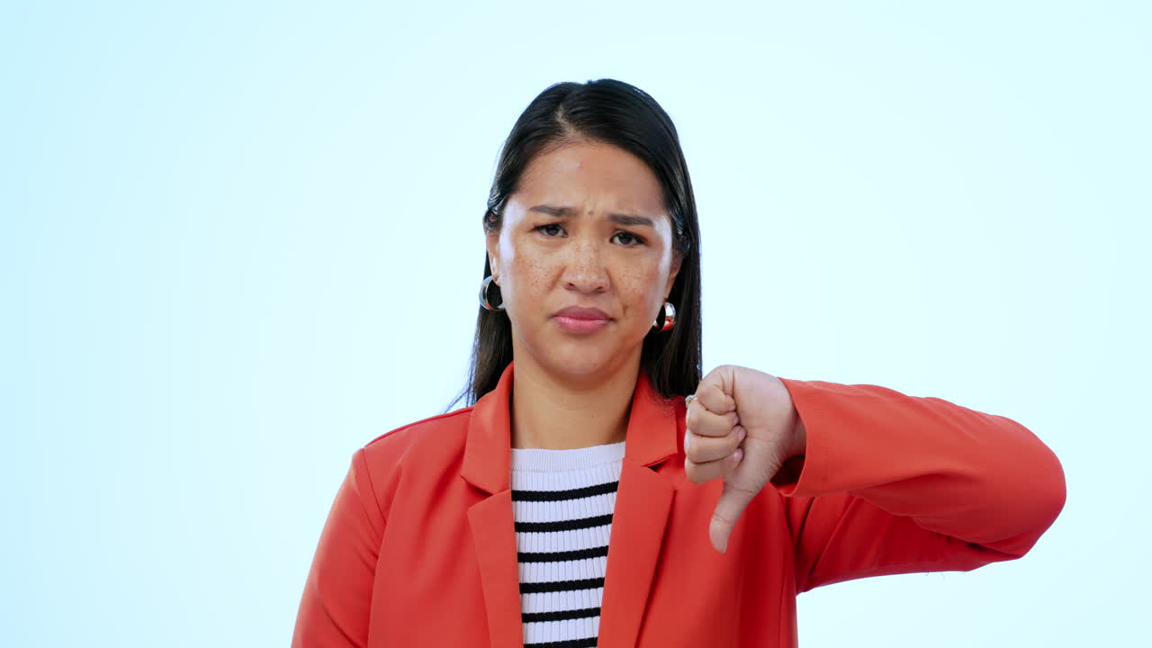 Thumbs down, upset and face of woman in a studio
