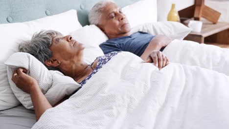 Worried-Senior-Woman-Waking-Up-Next-To-Husband-In-Morning