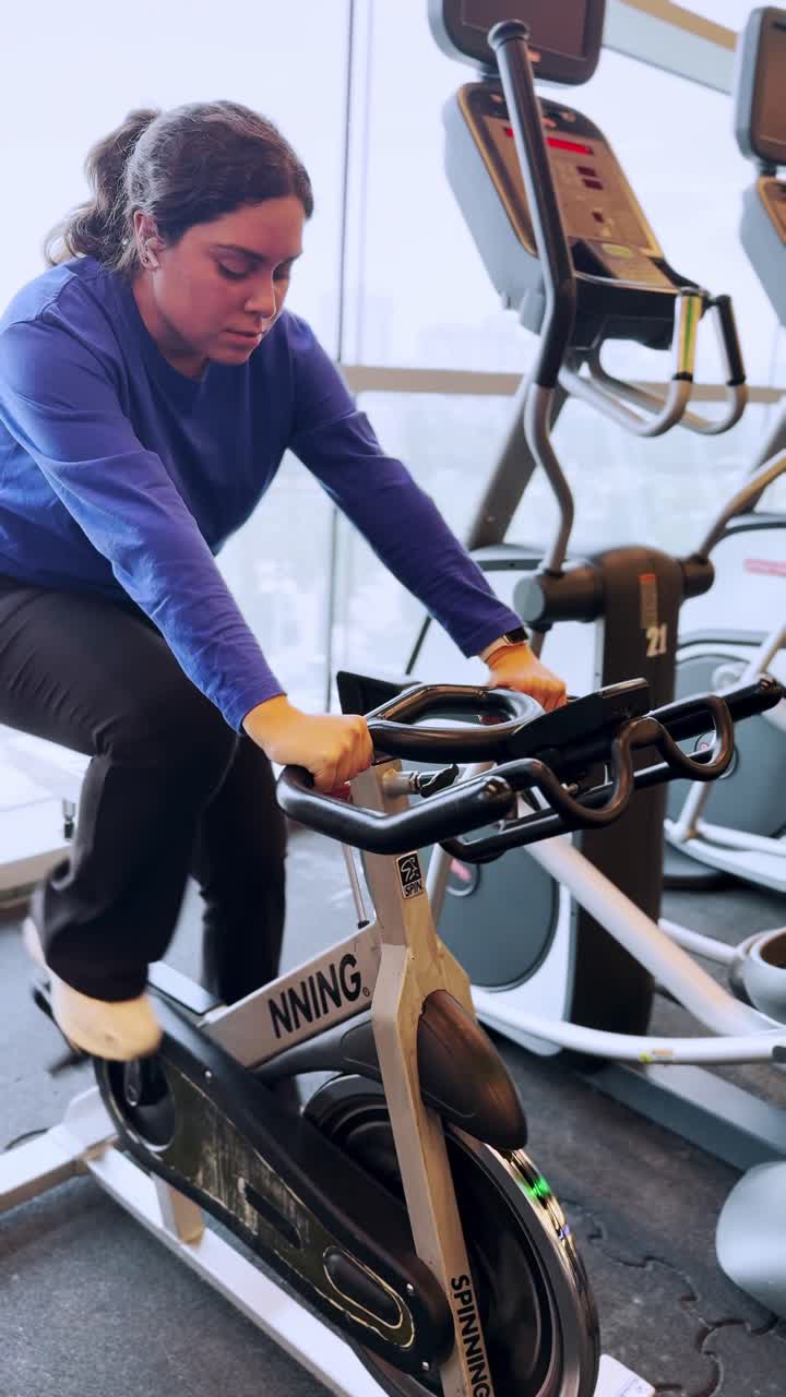 Young woman doing spinning exercise at the gym