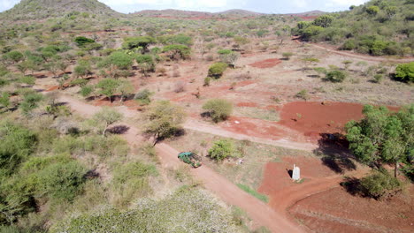 Filmische-Luftaufnahme-Eines-Lastwagens,-Der-Im-Ländlichen-Kenia-An-Ackerland-Vorbeifährt