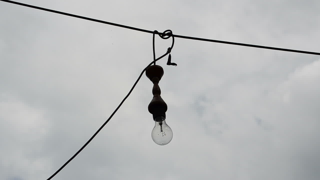 Glødelampen mod himlen. Lampe på en ledning
