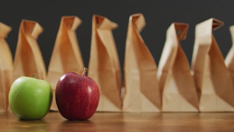 animación de bolsas de almuerzo de papel y frutas en una mesa de madera