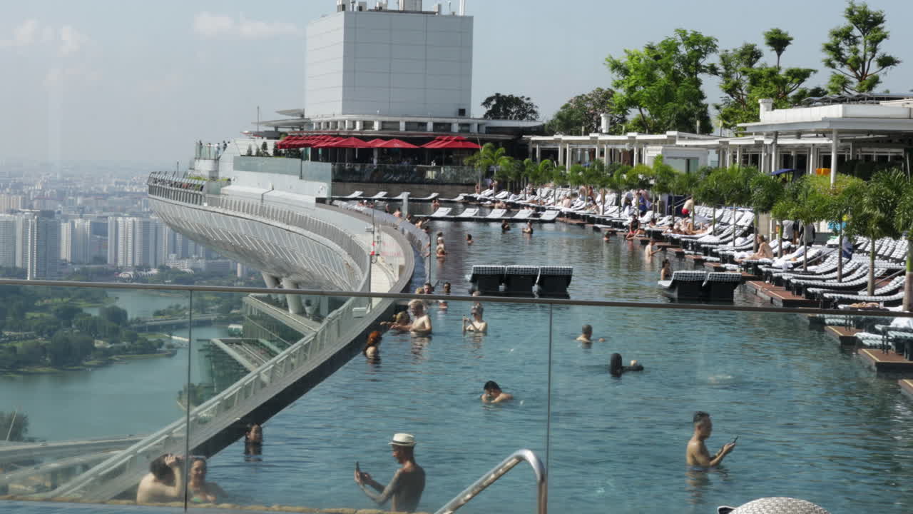 Tourists Enjoying The Infinity Pool At The Famous Marina Bay Sands In Singapore - Panning Shot