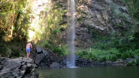 persona disfruta de una cascada serena y un entorno forestal